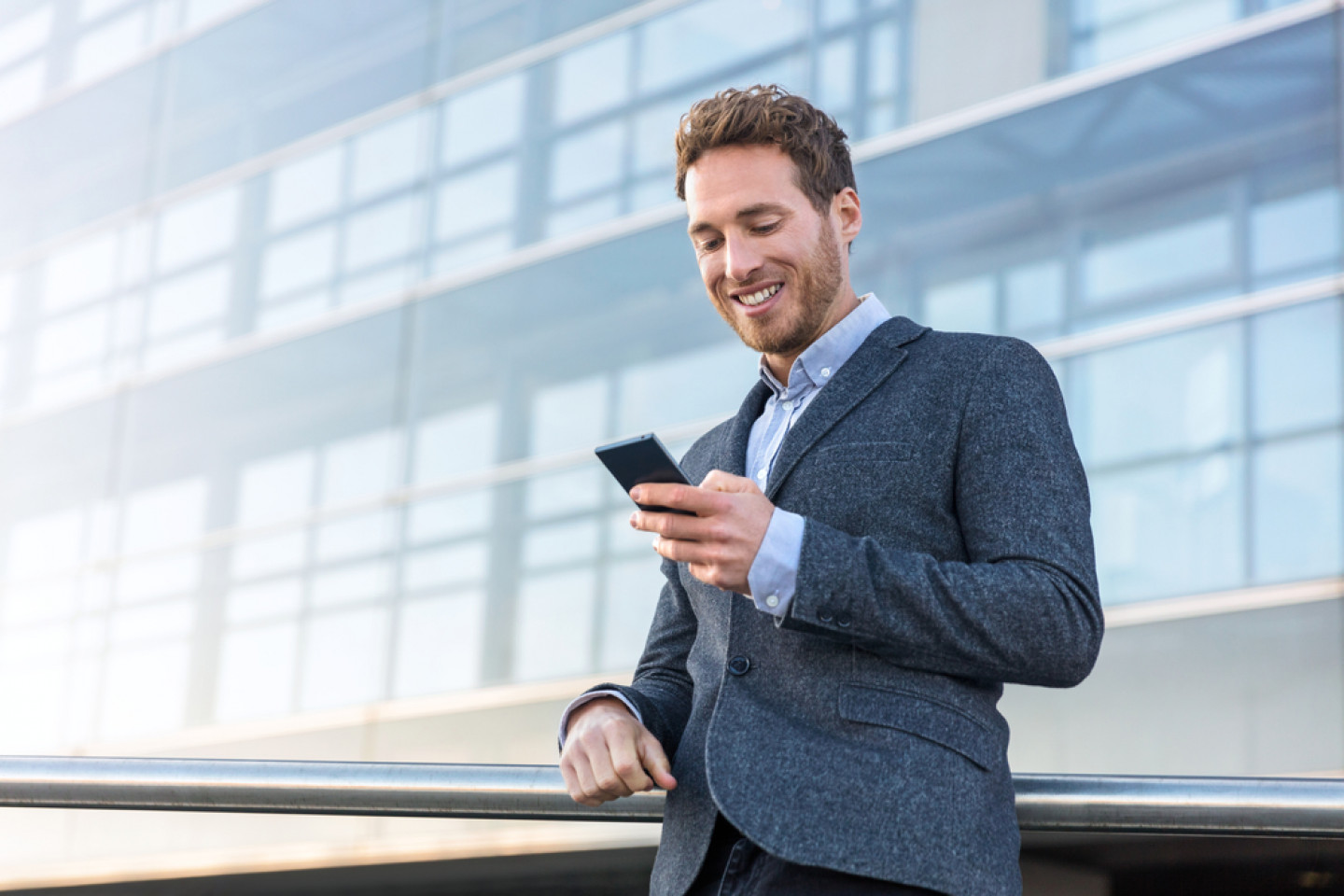 Businessman,Using,Mobile,Phone,App,Texting,Outside,Of,Office,In